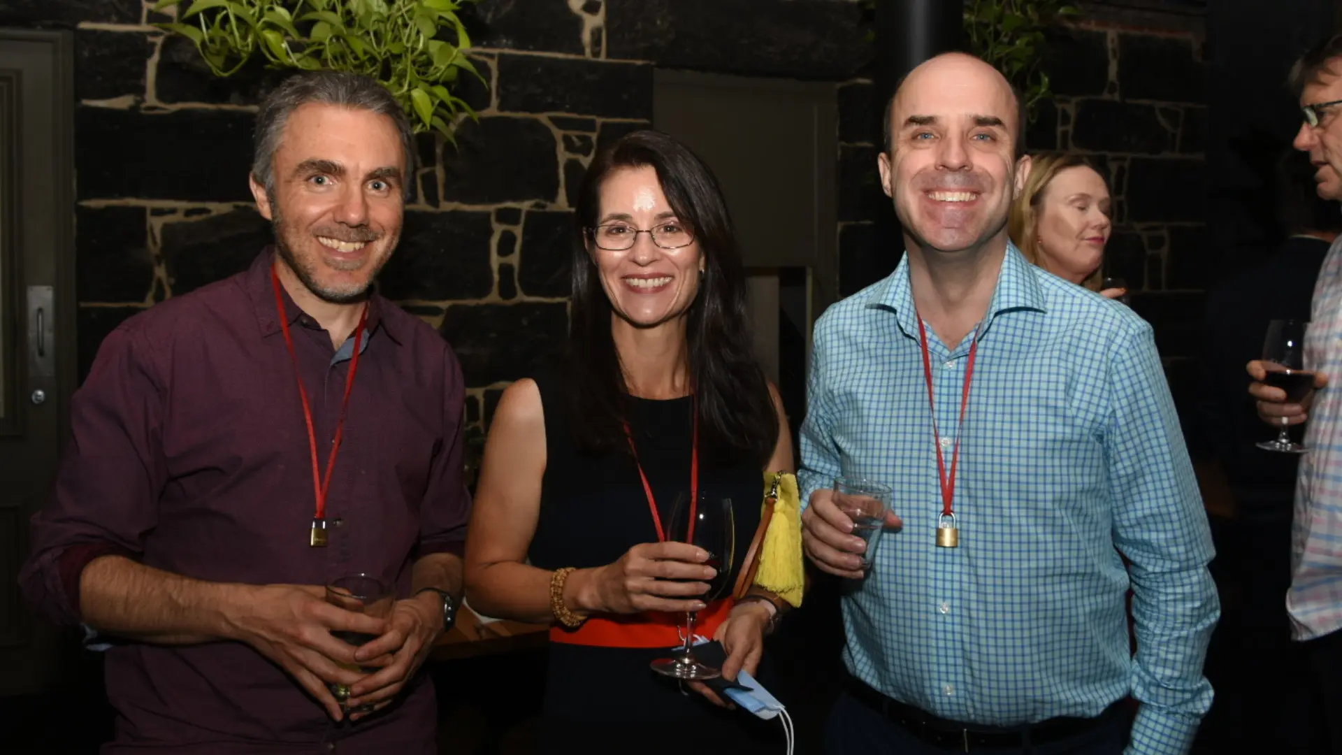 Three smiling guests with lanyards and padlock keepsakes at an Offline Valentine event by Mojo Mingle in Melbourne